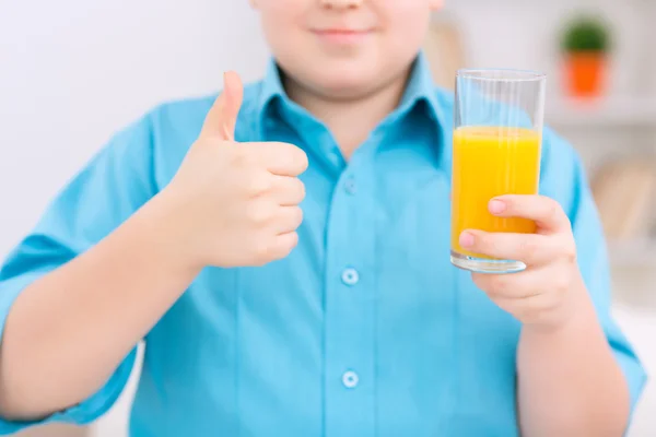 Ragazzo paffuto con un bicchiere di succo d'arancia . — Foto Stock