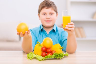 Chubby kid demonstrating healthy products. clipart