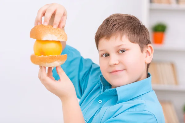 Ragazzo paffuto con panini e arancia . — Foto Stock