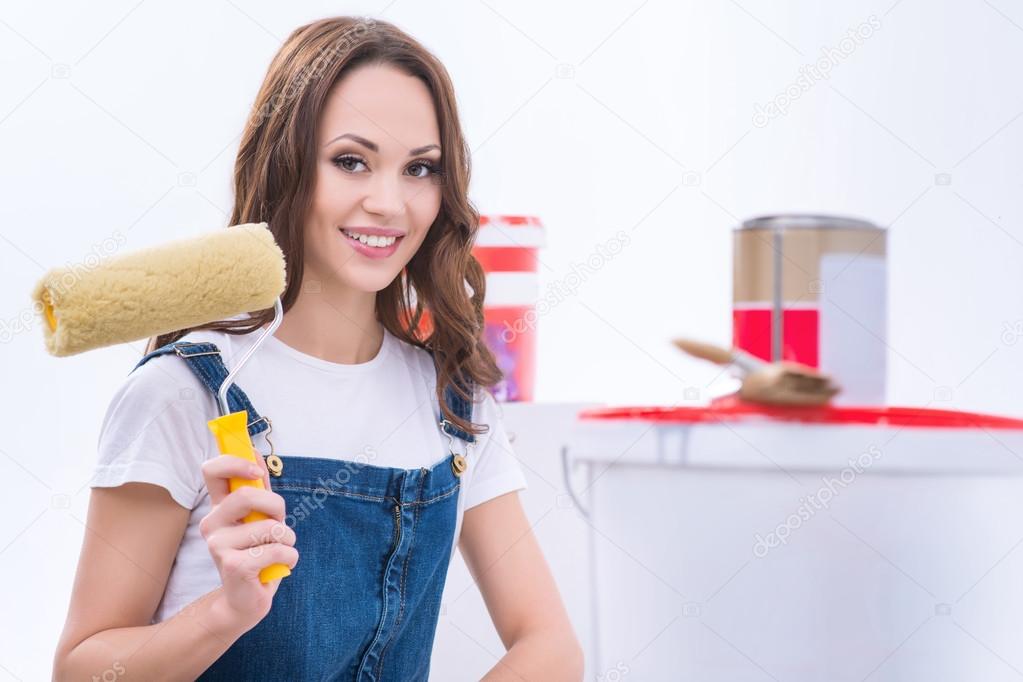 Girl in male role is holding a roller.