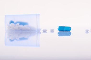 Pills falling out from open container. clipart