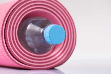 Yoga mat şişe su ile haddelenmiş