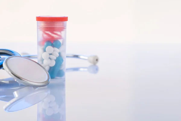 Pills and stethoscope are on the surface. — Stock Photo, Image