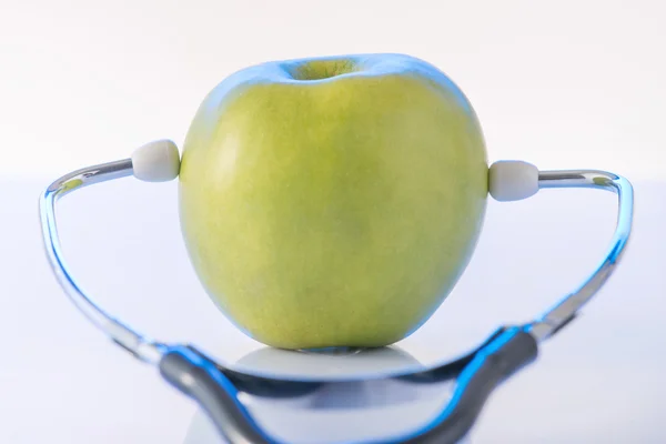 Green apple with doctors stethoscope. — Stock Photo, Image