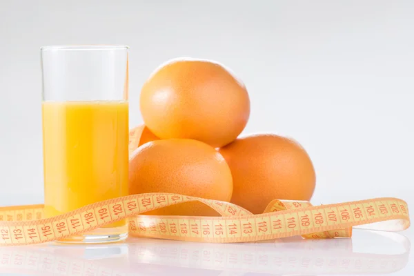 Naranjas, zumo fresco y cinta métrica . —  Fotos de Stock