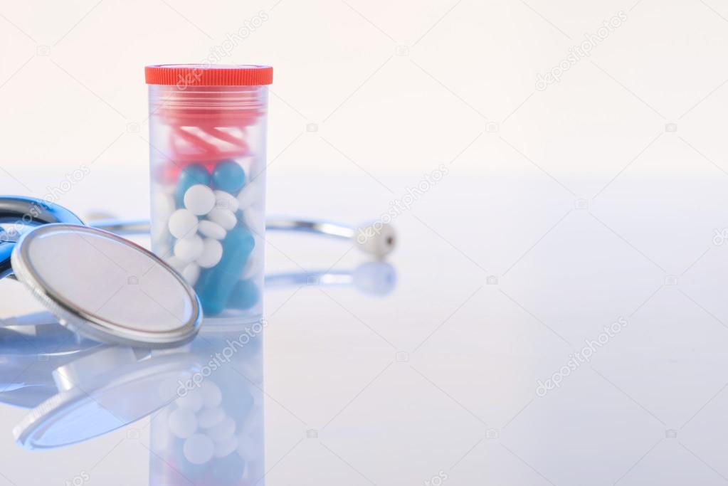 Pills and stethoscope are on the surface.