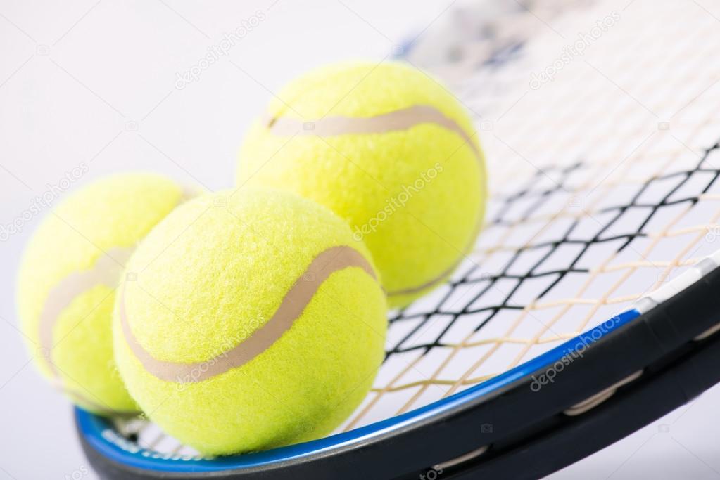 Three tennis balls and a racket.