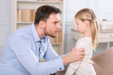 Strict father punishing his daughter