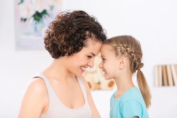 Mother and daughter are grinning to each other. — Stock Photo, Image