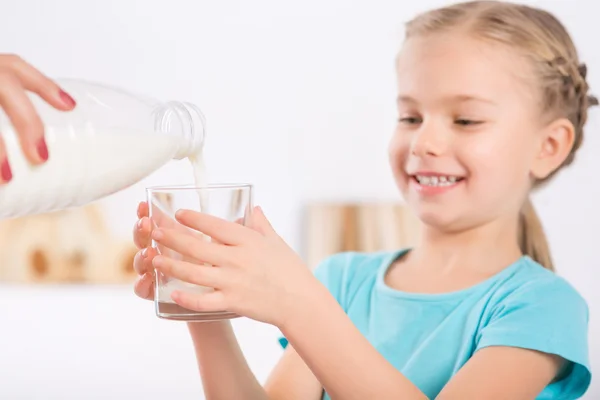 Daughter is upholding a glass for fresh cold milk. — Stockfoto