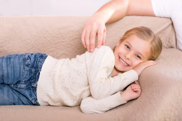 Милая маленькая девочка лежит на диване — стоковое фото