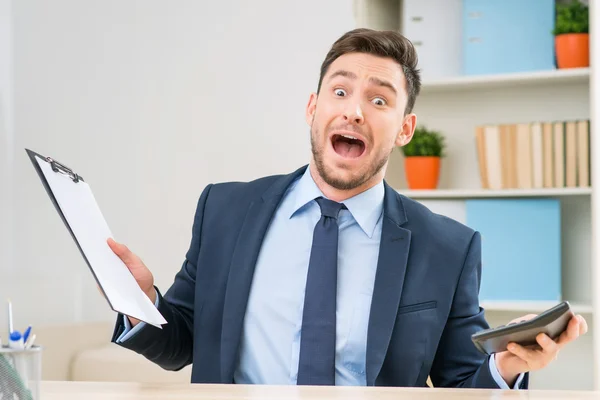 Emotional office worker sitting at the table — Stockfoto