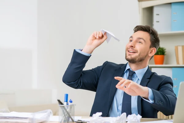 Bel lavoratore che gioca con la carta a tavola — Foto Stock