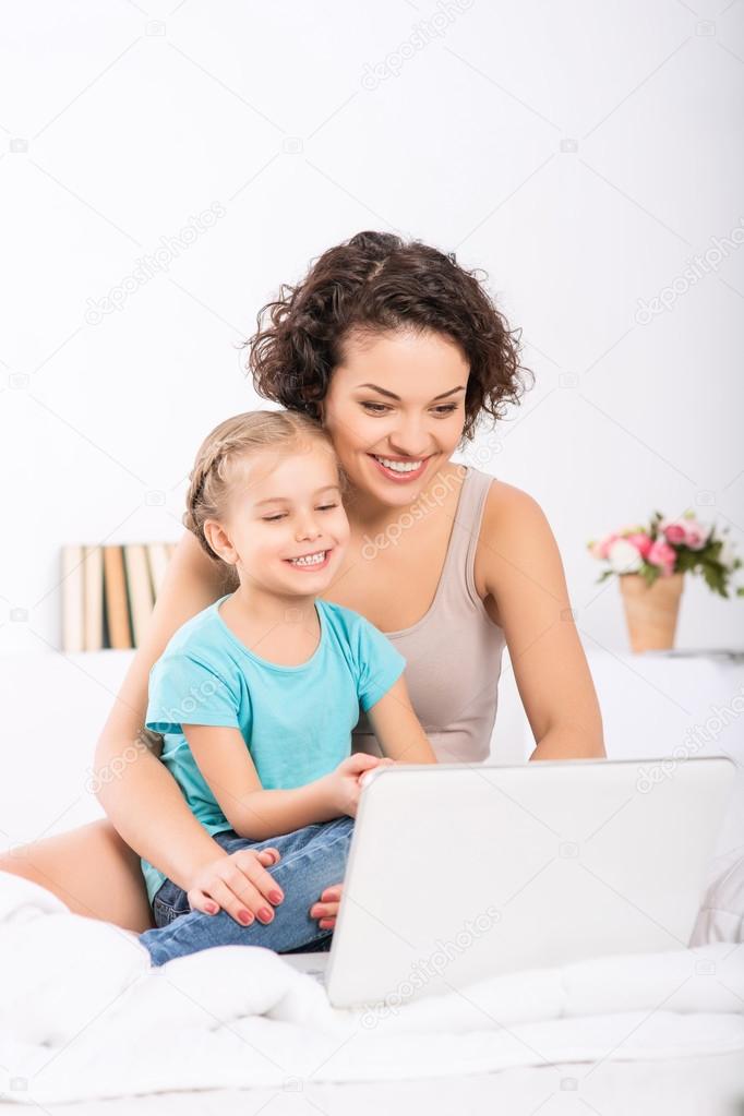 Mom and daughter are in front of laptop.