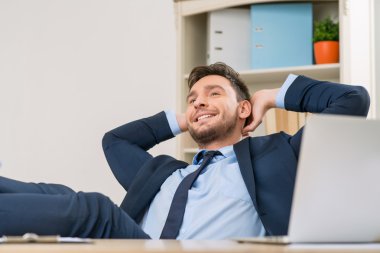 Overjoyed office worker sitting at the table