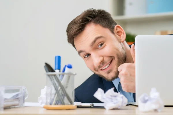 Pleasant office worker hiding behind laptop — 图库照片