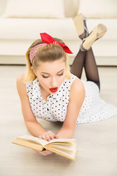 Jovem mulher atraente está lendo um livro . — Fotografia de Stock