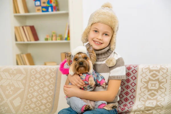 Dziewczynka i jej zwierzątko ubrany w ciepłą odzież. — Zdjęcie stockowe