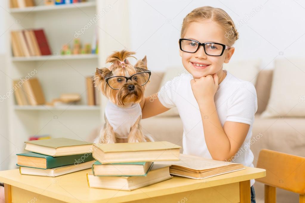 Little girl and her dog wearing glasses.