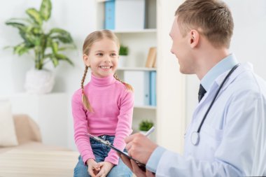 Küçük kız inceleyerek profesyonel çocuk doktoru