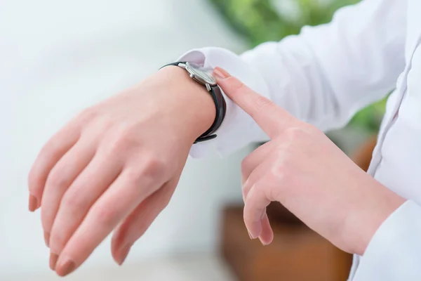 Mujer ocupada mirando su reloj de pulsera —  Fotos de Stock