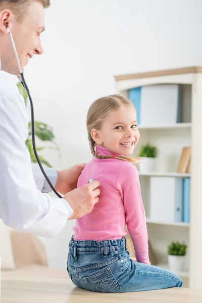 Pediatra profissional examinando menina — Fotografia de Stock