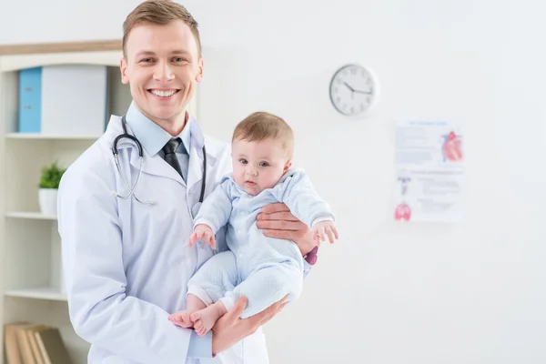 Professional pediatrician holding infant — Stock Photo, Image