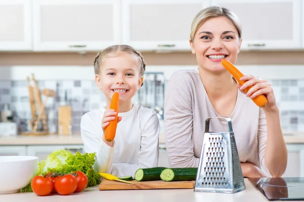 Mutter und Tochter essen Karotte — Stockfoto