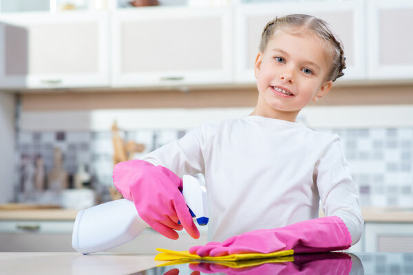 Маленькая девочка убирает кухню
