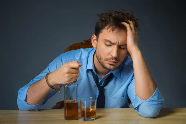 Betrunkener Mann trinkt Alkohol am Tisch — Stockfoto