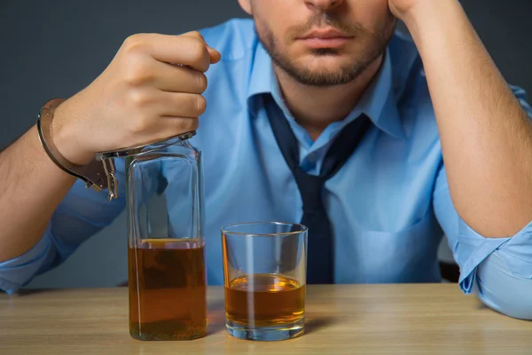 Un homme ivre buvant de l'alcool à table — Photo