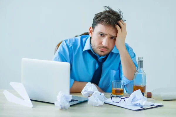 Drunk man drinking alcohol while working — Stock Photo, Image