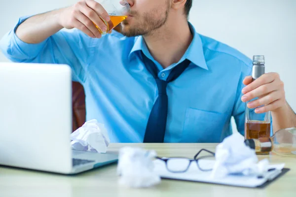 П'яний чоловік п'є алкоголь під час роботи — стокове фото