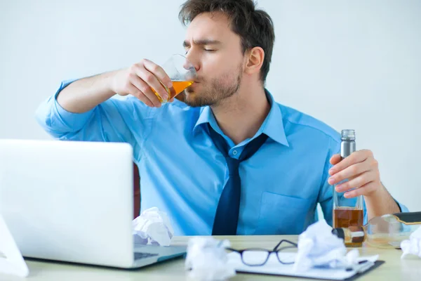 Drunk man drinking alcohol while working — Stock Photo, Image