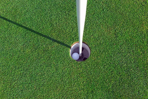 Bola de golfe e Flagstick de grama Mancured de colocar verde — Fotografia de Stock