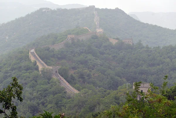 Great Wall of China atop the mountains in the forest, showing air pollution and smog, China