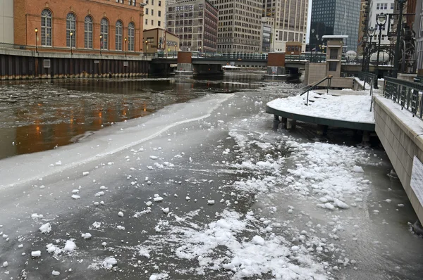 Cold winter scene with ice floating in river with icebergs and snow