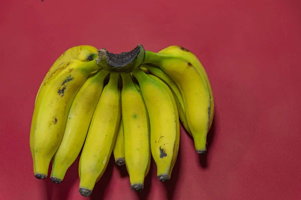 Banda Żółtych Bananów Banany Czerwonym Tle Egzotyczne Owoce Bogate Błonnik — Zdjęcie stockowe