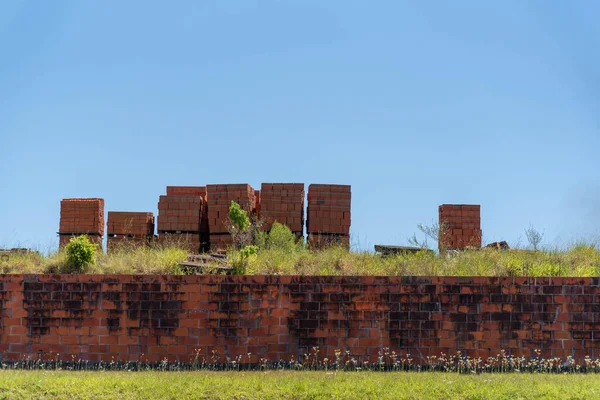 Masonry wall. Brick factory. Bricks stacked in paddle for transport. Pottery deposit.