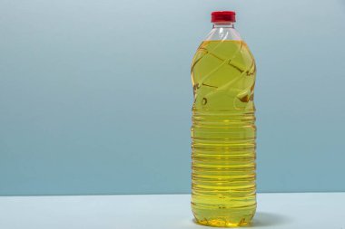 Bottles of edible soy oil on blue background. Olive oil for salads and cooking in general. Soybean oil is extracted from soybean seed and is used as a food source and as biofuel.