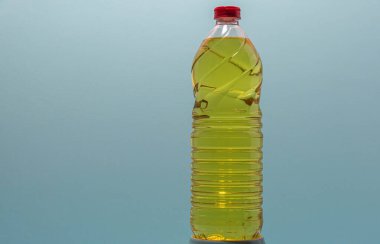 Bottles of edible soy oil on blue background. Olive oil for salads and cooking in general. Soybean oil is extracted from soybean seed and is used as a food source and as biofuel.