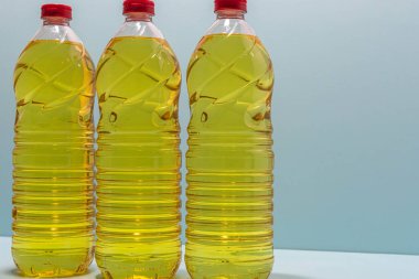 Bottles of edible soy oil on blue background. Olive oil for salads and cooking in general. Soybean oil is extracted from soybean seed and is used as a food source and as biofuel.