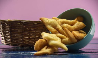 Fried wheat dumplings known as chiacchiere or cat's ear. Gluten-based food. Italian dumplings also called Crostoli, cavaquinho, ceroula turned in Brazil or coscoro in Portugal