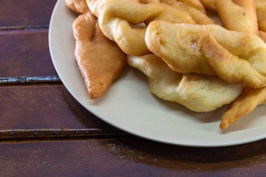 Fried wheat dumplings known as chiacchiere or cat's ear. Gluten-based food. Italian dumplings also called Crostoli, cavaquinho, ceroula turned in Brazil or coscoro in Portugal