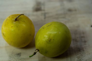 Ahşap inşaat arka planında sarı çarkıfelek meyveleri (Passiflora edulis Sims). Meyve, Passiflora cinsinden bitkiler tarafından üretilir. Amerika 'nın tropik bitkisi.