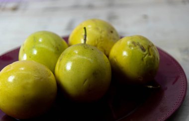 Sarı çarkıfelek meyvesi (Passiflora edulis Sims) kırmızı tepside. Meyve, Passiflora cinsinden bitkiler tarafından üretilir. Amerika 'nın tropik bitkisi.