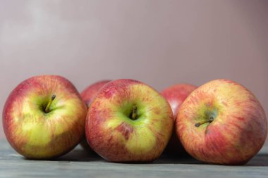 Tarafsız bir zeminde kırmızı elma meyveleri. A vitamini, kalsiyum ve C vitamini açısından zengin meyveler düşük kalorili yiyecekler. Meyve suyu ve salata için serbest. Doğal gıda ve detoks..