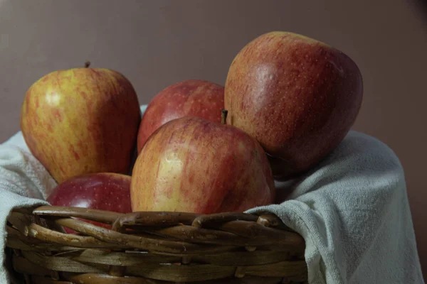 Apple fruits in wooden basket on neutral background. Fruit rich in vitamin A, calcium and vitamin C. Low calorie food. Infredient for juices and salads. Natural food and detox.