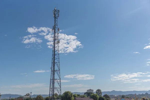 Cell phone data transmission tower on blue natural background. Communication data transmission infrastructure. Natural landscape. Metal structure.