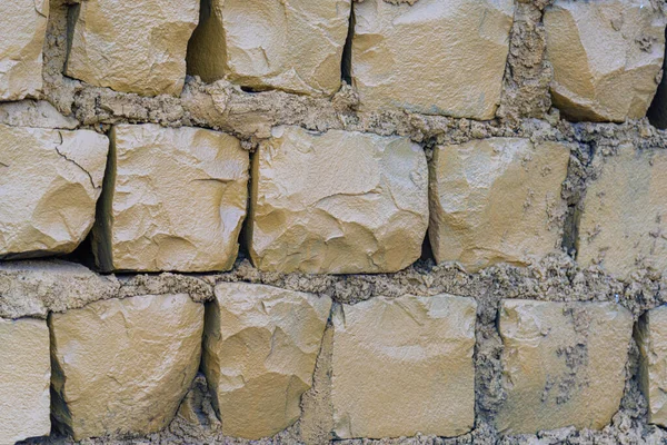 Urban retaining wall built with basalt stones. Rock wall of basaltic rock. Basaltic stones with grout with cement and mortar. Texture.